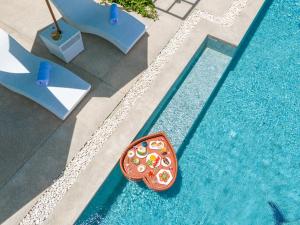 a pool with a tray of pizza on the side at 宛如梦境 一线海景6卧室别墅 超大私人泳池 免费早餐接机 私人影院健身房 in Phuket Town