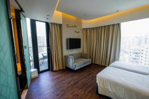 a hotel room with a bed and a chair and window at Epoch Hotel in Hong Kong