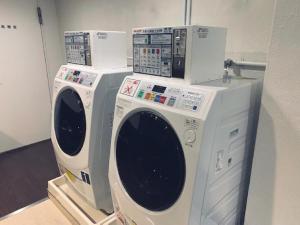 due lavatrici sovrapposte l'una all'altra di Hotel Trusty Nagoya Shirakawa a Nagoya