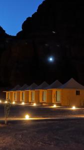 a building at night with the moon in the sky at Rum desert magic in Wadi Rum