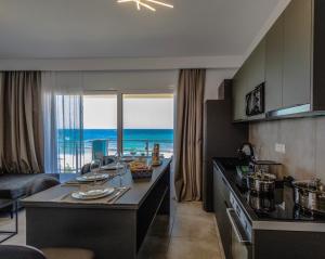 a kitchen with a table with a view of the ocean at Stegna Sea & Sun in Archangelos