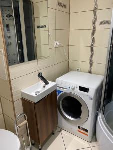 a bathroom with a washing machine and a sink at Łódź Widzew-wschód in Łódź