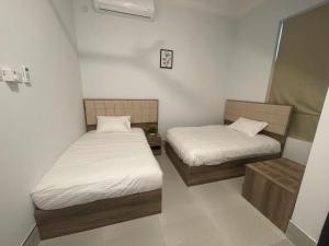 two beds in a small room with white sheets at ALOEVERA VILLAS & CAFA in Sayq