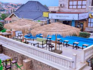 un patio con tavoli, sedie e ombrelloni di KEZA Home a Kigali