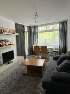 a living room with a couch and a table at 2 Zimmer Appartement mit Pool im Haus in Schluchsee