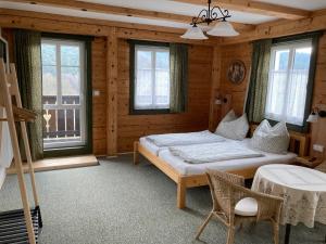 Penzion Henke في Srbská Kamenice: غرفة نوم مع سرير في غرفة مع نوافذ