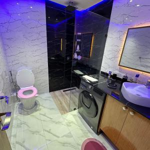 ein Badezimmer mit einer rosa Toilette und einem Waschbecken in der Unterkunft Wood-Finish Home Pool Premium Bedding Self-Check in 7 Min from Marina in Agadir