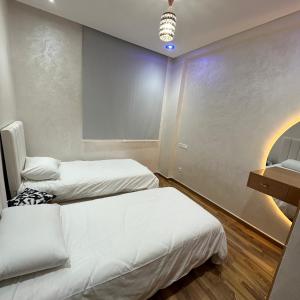 Zimmer mit 2 Betten und einem Waschbecken. in der Unterkunft Wood-Finish Home Pool Premium Bedding Self-Check in 7 Min from Marina in Agadir