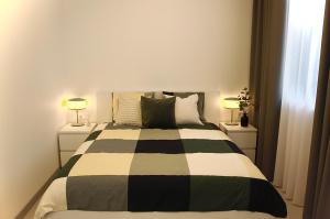 a bedroom with a black and white bed with two lamps at Mazvydo studio appartment in Klaipėda