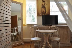 ユオドクランテにあるJuodasis Kalnasのテーブルと椅子、テレビが備わる客室です。