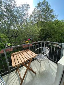a wooden table and a chair on a balcony at Apartment_Lucas in Hamburg