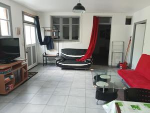 salon z kanapą i telewizorem w obiekcie Eco domaine 12hectares meublé pour 6 personnes w mieście Plouray