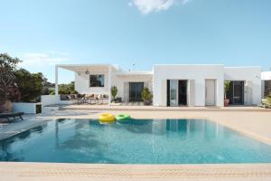 a villa with a swimming pool in front of a house at Villa Paraga in Platis Gialos