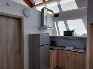 a kitchen with a stainless steel refrigerator and a window at Szárszó Apartmanok in Balatonszárszó