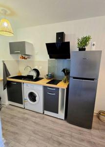 a kitchen with a refrigerator and a washing machine at Élégant studio Les Tourtereaux in Saint-Denis