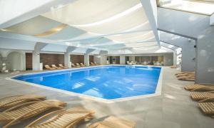 a pool in a building with chairs and a swimming pool at Hotel Excelsior - Liburnia in Lovran