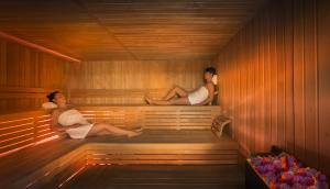 two people are sitting in a sauna at Hotel Excelsior - Liburnia in Lovran