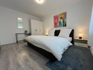 una camera da letto con un grande letto con lenzuola bianche di Serene Meadows Apartment a Solingen