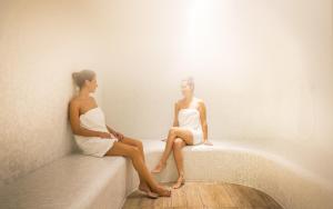 two women in white sitting on a wall at Hotel Excelsior - Liburnia in Lovran