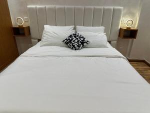 ein großes weißes Bett mit zwei Kissen darauf in der Unterkunft Wood-Finish Home Pool Premium Bedding Self-Check in 7 Min from Marina in Agadir + 55 Fotos