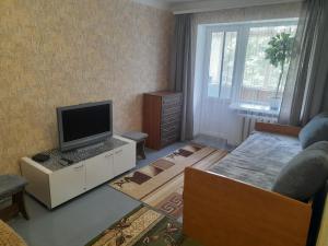 a living room with a flat screen tv and a couch at Квартира біля центрального парку, район Покровського собору на Княгині Ольги 13 in Rivne