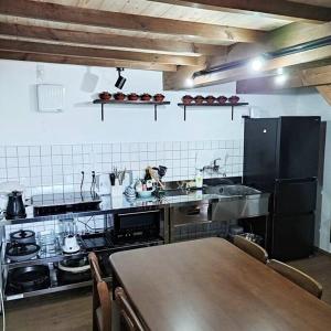 a kitchen with a table and a counter top at vacation house WAKURA わ蔵 in Tomi +31 photos