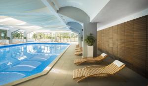 a large swimming pool with chairs and a swimming pool at Hotel Excelsior - Liburnia in Lovran