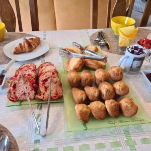 una mesa con pan y bollería en Chambres d'Hôtes La Quèrière en Mur-de-Sologne