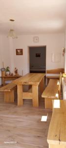 una gran mesa de madera en una habitación con bancos en Chata Chotár Nová Baňa, en Veľká Lehota
