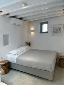 a white bedroom with a bed and a window at Apollonion house in Apollonia