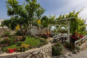 a garden with a bench and some flowers at Apartments Villa Katarina in Tučepi