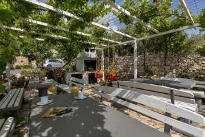 a patio with a table and chairs under a pergola at Apartments Villa Katarina in Tučepi