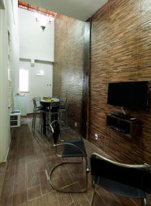 Habitación con mesa y TV en la pared. en Casa Saga - All Suites en Río de Janeiro