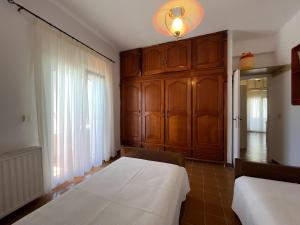 a bedroom with a bed and a large wooden cabinet at katerina`s house in Kefalos