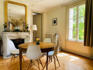 a dining room with a table and chairs and a mirror at MAISON 54 in Bernay