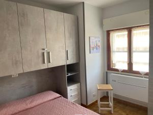 una camera con letto, finestra e armadi di Scacciapensieri house a Nettuno