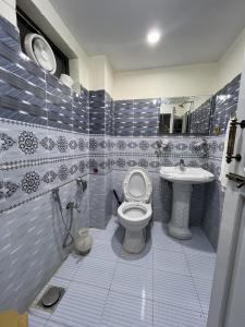a bathroom with a toilet and a sink at Blue Sky Hotel & Restaurant in Skardu