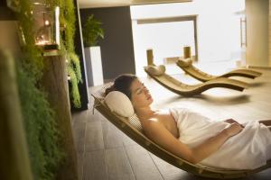 a woman laying in a hammock in a room at Hotel Excelsior - Liburnia in Lovran