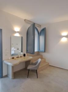 Habitación con mesa, silla y espejo. en Pegasus Spa Hotel, en Imerovigli