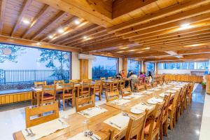 een grote eetkamer met houten tafels en stoelen bij Nagarkot Shangrila Resort in Nagarkot