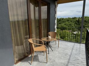 un patio con 2 sillas y una mesa en el balcón en Lake House, en Tskaltubo