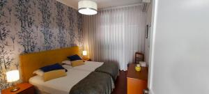 ein Hotelzimmer mit einem Bett mit blauen Kissen in der Unterkunft Vila Calaça in Funchal