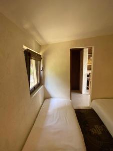 mały pokój z łóżkiem i oknem w obiekcie Domek przy Promenadzie Zdrojowej w Gołdapi