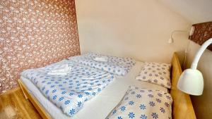 2 camas en una habitación con sábanas azules y blancas en Vinný Sklep Monty Velké Bílovice, en Velké Bílovice