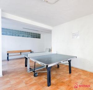 - une table de ping-pong dans une pièce avec un banc dans l'établissement La Postal, à Benicàssim