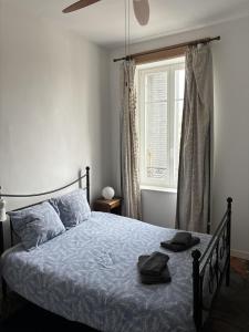 1 dormitorio con cama con sábanas azules y ventana en 2 bed apartment fantastic roof terrace-town centre, en Montmorillon