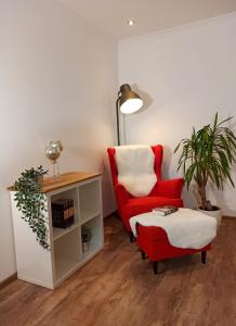 uma sala de estar com uma cadeira vermelha e uma mesa em Haus Starkenburg em Enkirch