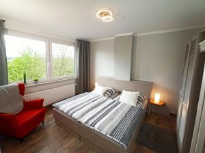 um quarto com uma cama e uma cadeira vermelha em Haus Starkenburg em Enkirch