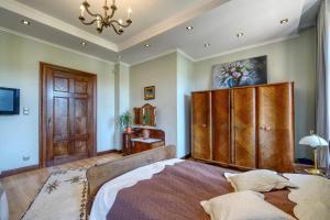 a bedroom with a large bed and a wooden cabinet at APARTAMENT & SPA Dworski Zakątek in Reda