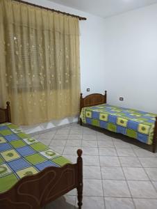 two beds sitting in a room with a curtain at Private Home Durres in Durrës